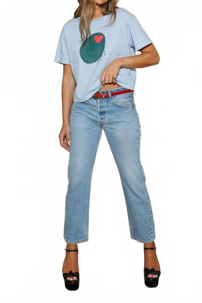 Woman wearing an ice blue Olive You! tee with jeans and black heels 