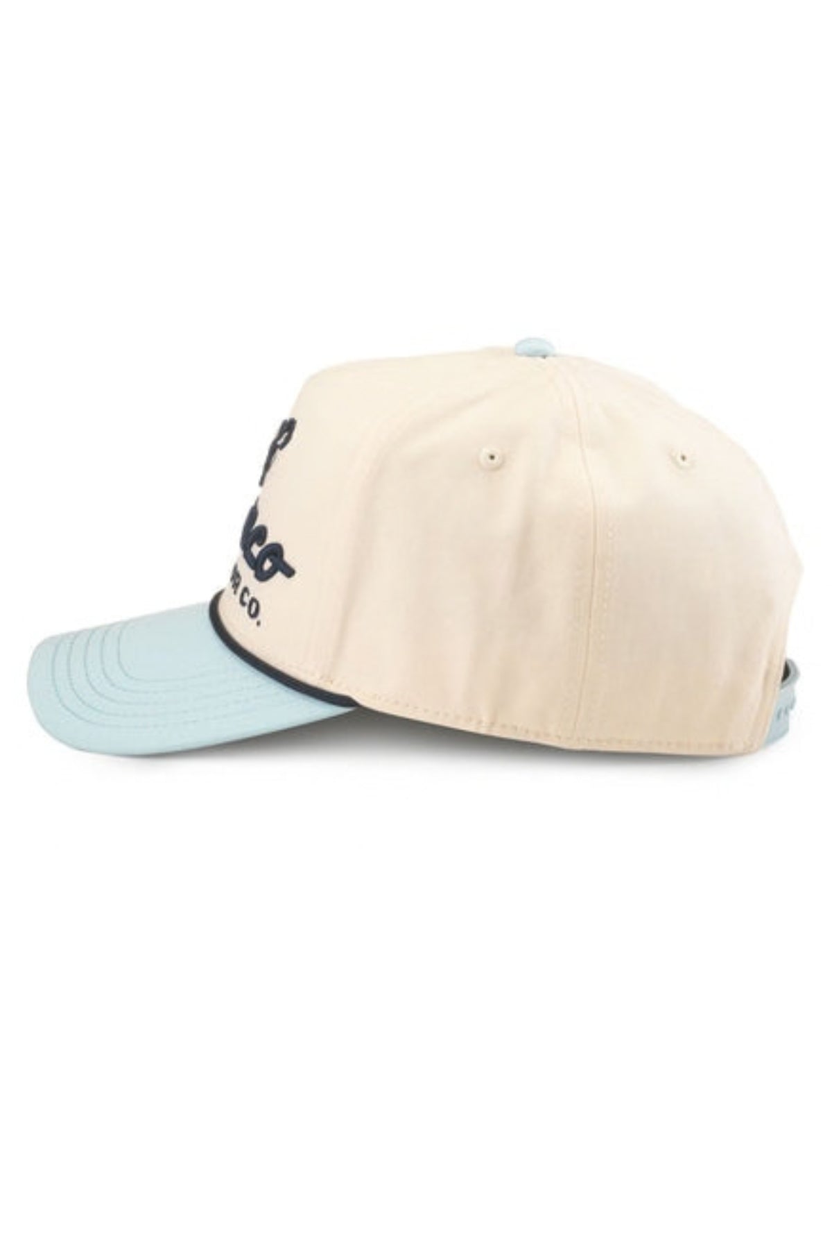 A baseball cap with a cream-colored crown and a light blue visor, featuring a black embroidered logo on the side.