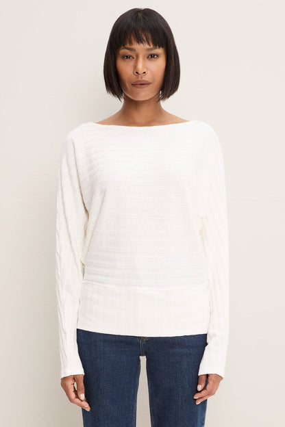 Woman wearing Fleur Boatneck Dolman Sleeve Top in Coconut Milk color with dark blue jeans 