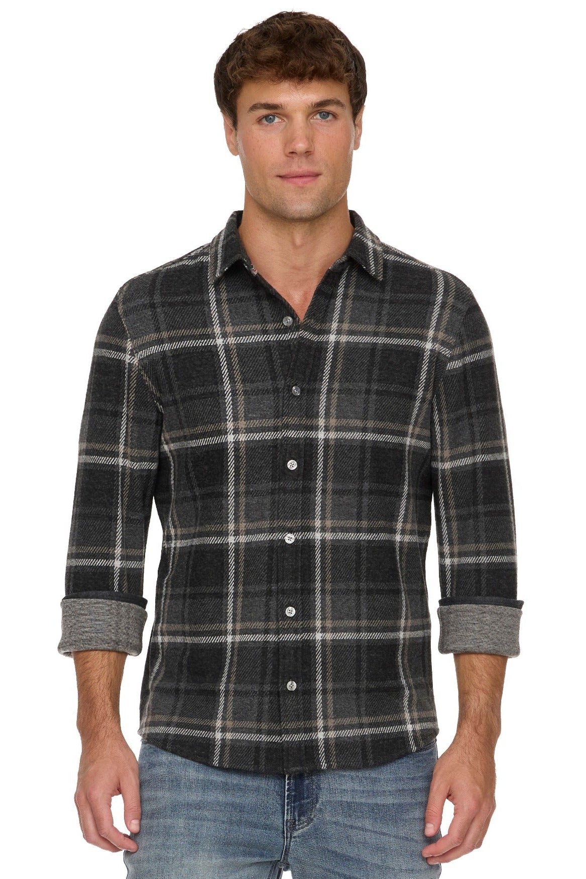 A man wearing a Wadley dark charcoal gray and black plaid button-down shirt with rolled-up sleeves, paired with blue jeans, against a plain white background.