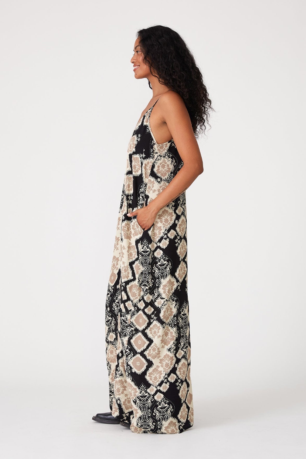 Woman wearing a black & khaki patterned dress on a white background