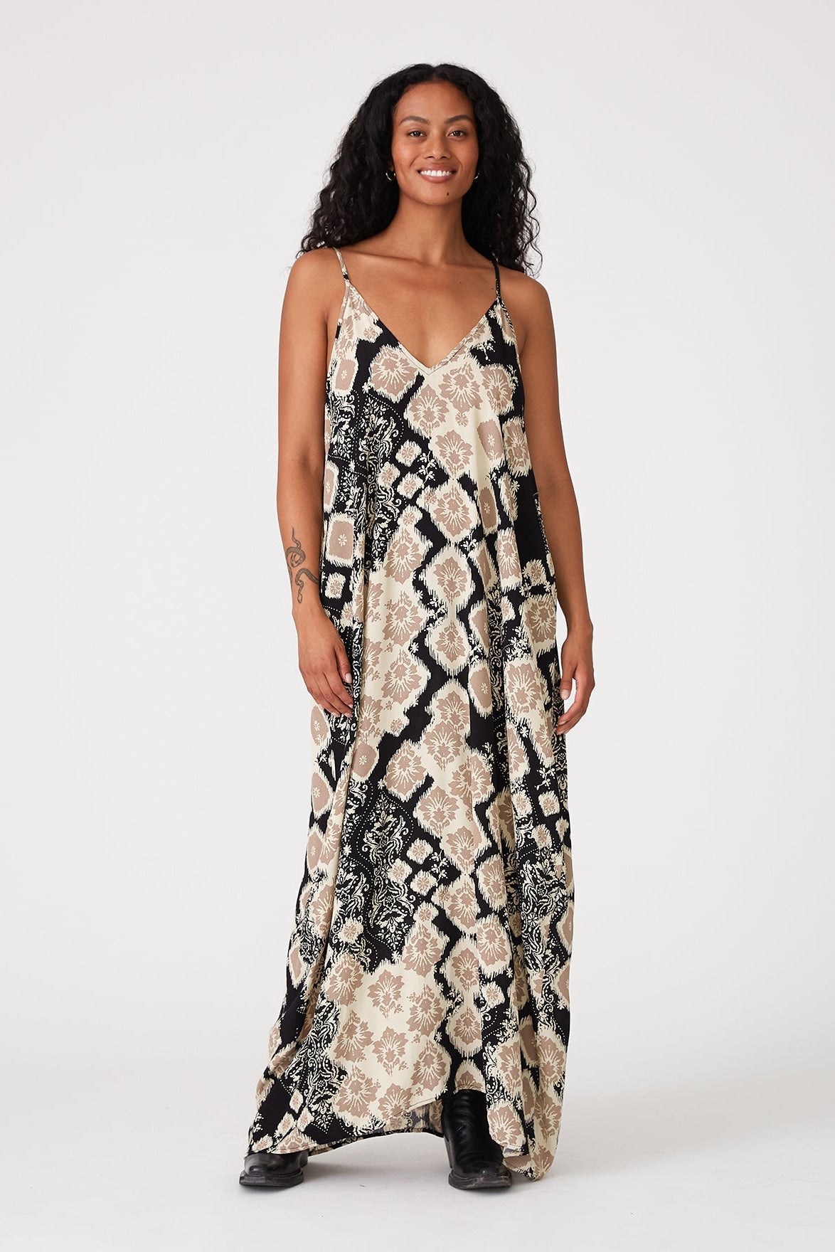 Woman wearing a black & khaki floral patterned dress on a white background