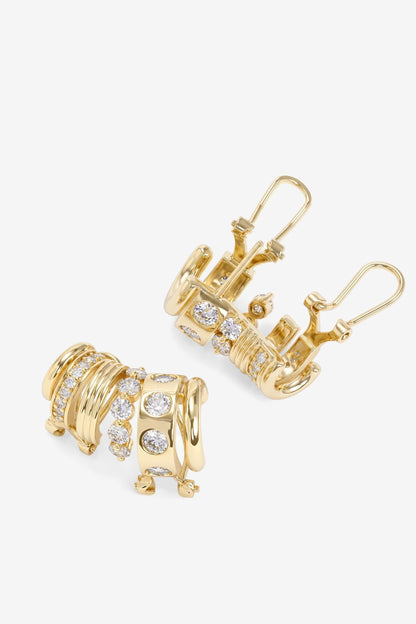 A pair of gold Ashley Venice Ear Crawler huggie hoop earrings decorated with multiple rows of small clear pavé gemstones, shown on a clean white background.