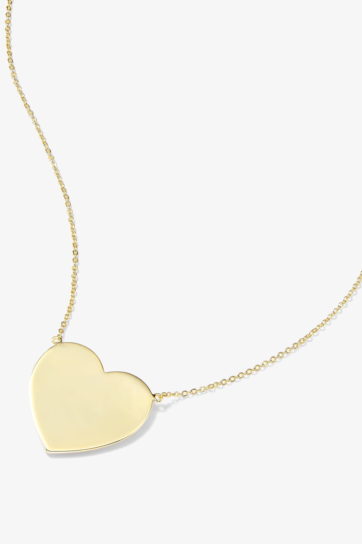A gold heart-shaped pendant necklace on a delicate gold chain, shown against a light gray background.