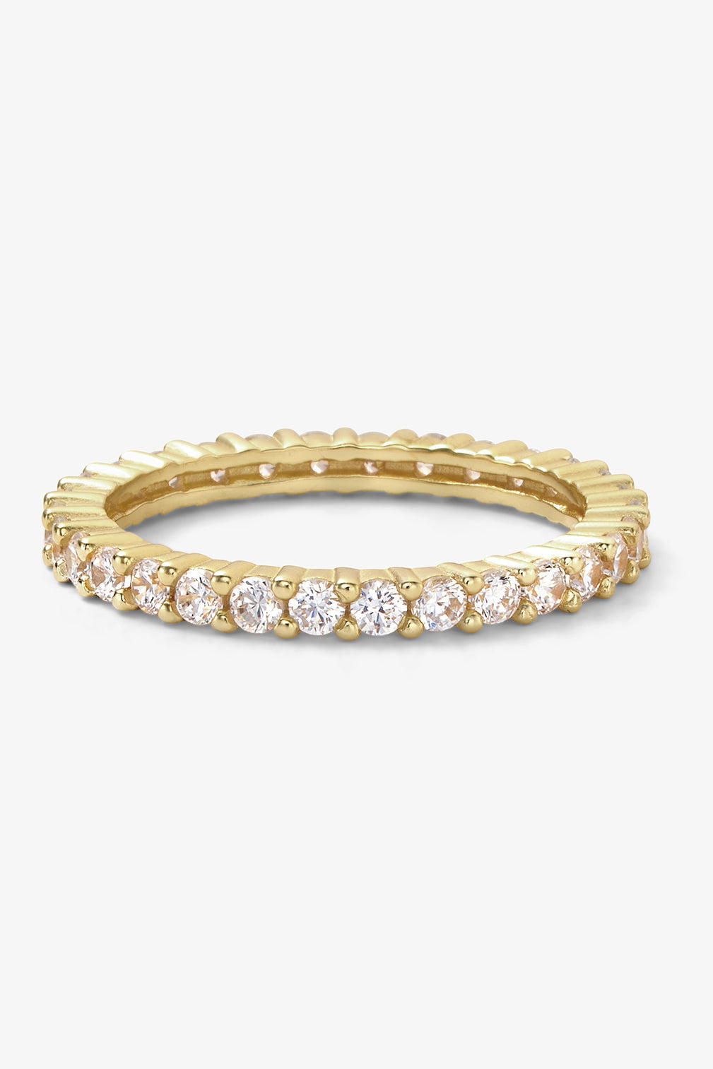 A yellow gold eternity baby heiress ring featuring a row of round-cut clear gemstones set in a continuous band, shown on a light gray background.