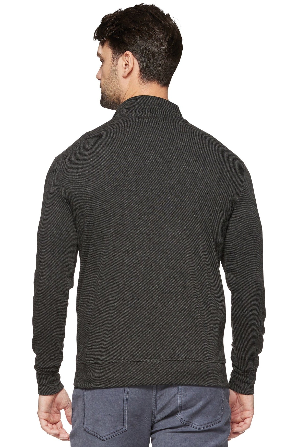 A man viewed from the back wearing a dark charcoal gray mock neck long-sleeve sweater and gray pants, against a plain white background.