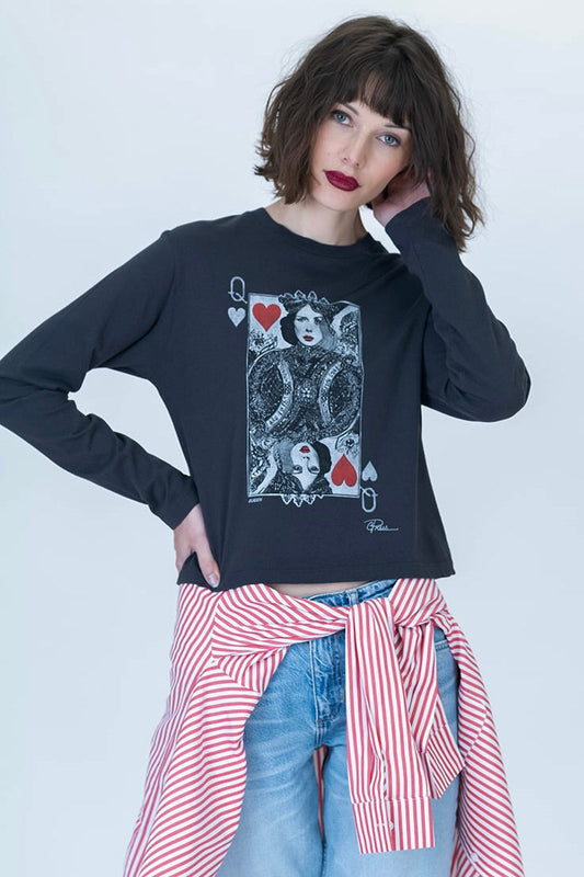 A model wearing a black long-sleeve graphic t-shirt featuring a Queen Sunday playing card design, paired with light blue jeans and a red-and-white striped shirt tied around the waist, against a plain light gray background.
