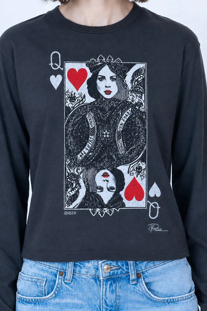 A person wearing a black long-sleeve graphic T-shirt featuring a Queen of Hearts playing card design with red hearts and white/black illustration details, paired with light blue jeans against a light gray background.
