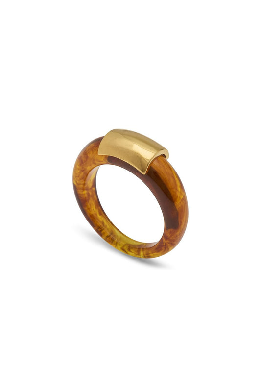 A chunky ring featuring a marbled amber-tortoise brown translucent band with a polished gold metal top accent, shown on a clean white background.