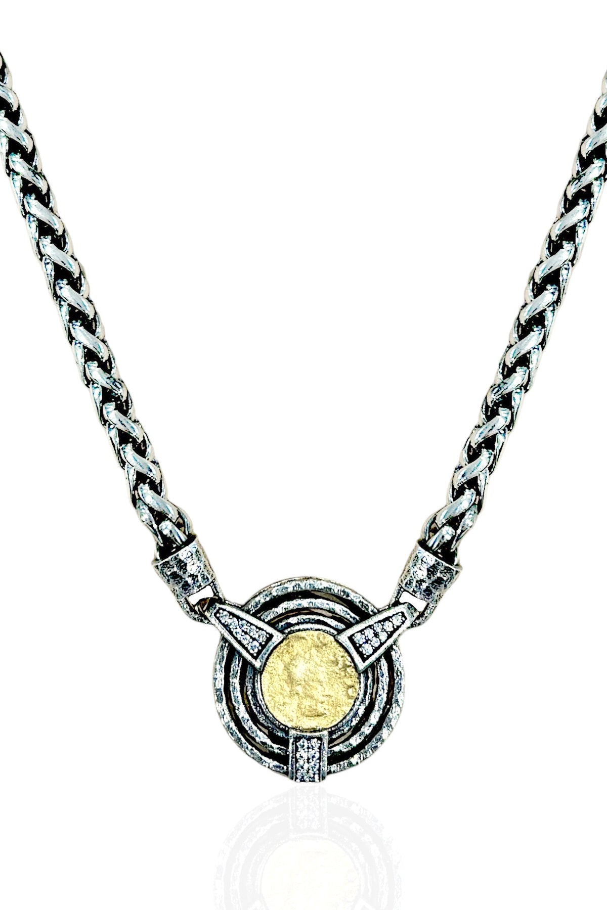 A silver-toned chain necklace with a circular pendant featuring a textured gold coin in the center, surrounded by concentric rings and small clear stones, shown on a white background.