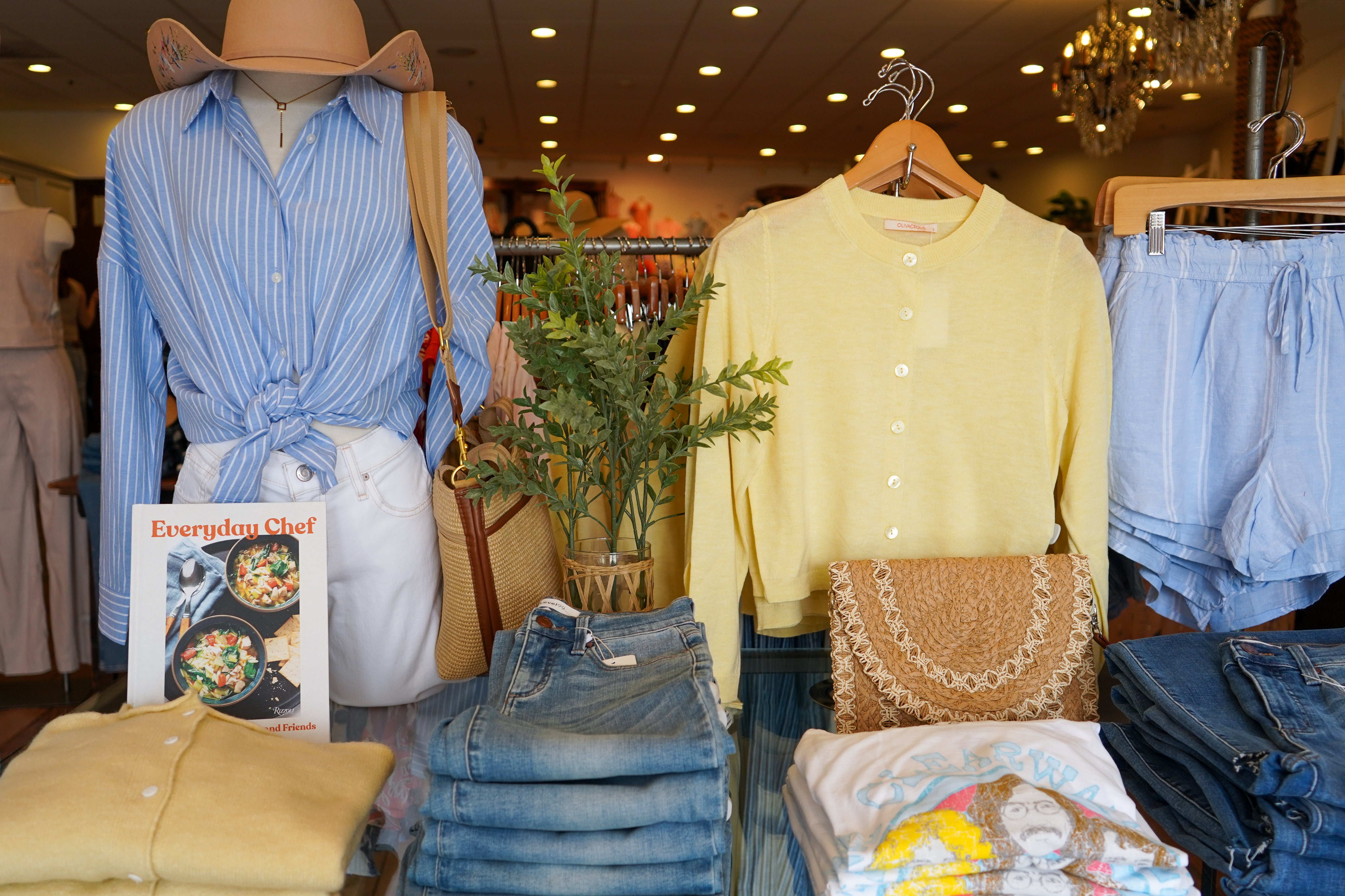 A boutique merchandise table with women's clothing and accessories.