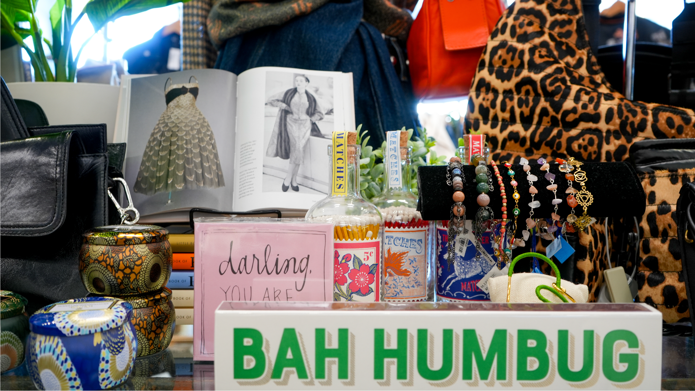 Display of various items including books, a leopard print bag, and a 'Bah Humbug' sign.